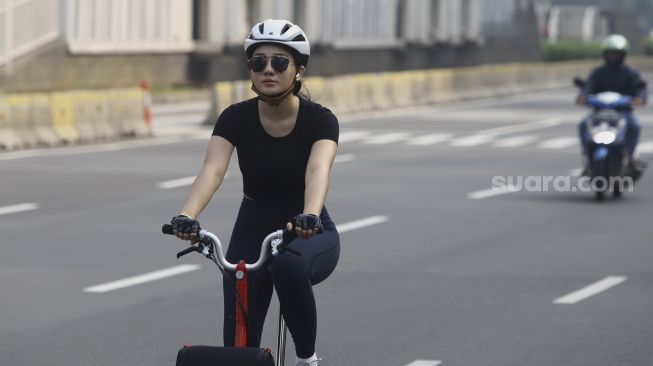 Warga berolahraga menggunakan sepeda di Jalan Jenderal Sudirman, Jakarta, Minggu (7/6). [Suara.com/Angga Budhiyanto]