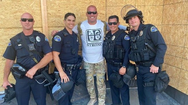 Mantan juara dunia kelas berat ringan UFC, Tito Ortiz (tengah), berfoto bersama anggota kepolisian Huntington Beach. [Instagram@titoortiz1999]