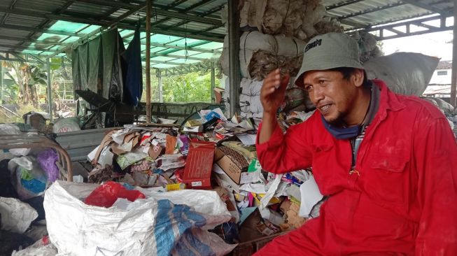 Supartono, pemilah sampah anorganik di Kelompok Usaha Pengelola Sampah (Kupas) Panggungharjo, Sewon, Bantul, menceritakan pengalaman saat diberitakan koran Australia setelah selamat dari badai salju, Selasa (9/6/2020). - (SuaraJogja.id/Mutiara Rizka)