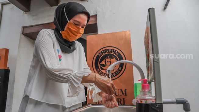 Pengunjung diwajibkan mencuci tangan sebelum masuk ke dalam Museum Bahari, Jakarta Utara, Selasa (9/6). [Suara.com/Alfian Winanto]