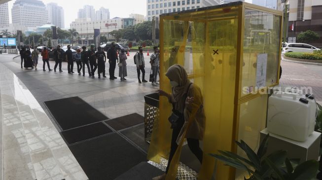 Pengunjung keluar dari bilik disinfektan sebelum memasuki Mal Senayan City, Jakarta, Selasa (9/6). [Suara.com/Angga Budhiyanto]