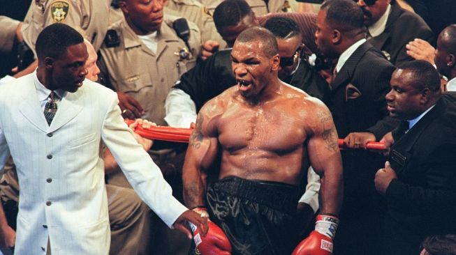 Temperamen Mike Tyson (tengah) tak terkendali usai didiskualifikasi dalam pertarungan kedua melawan Evander Holyfield di MGM Grand Garden Arena, Las Vegas, Sabtu (28/6/1997). [AFP/John Gurzinski]