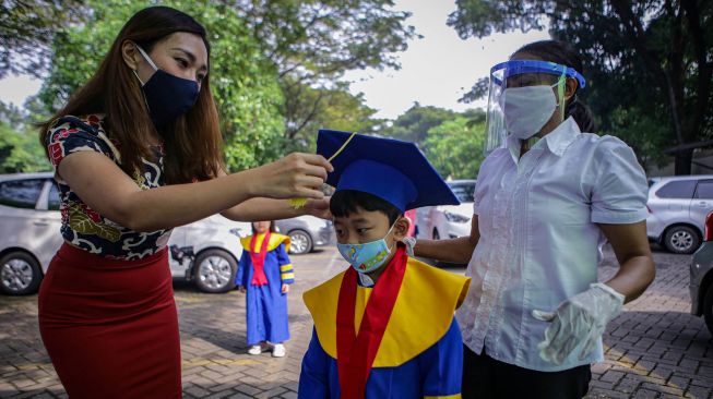 Siswa sekolah Stella Maris bersiap sebelum mengikuti acara kelulusan secara 'drive thru' di Stella Maris School, Kelapa Dua, Kabupaten Tangerang, Banten, Selasa (9/6/2020).  [ANTARA FOTO/Fauzan]