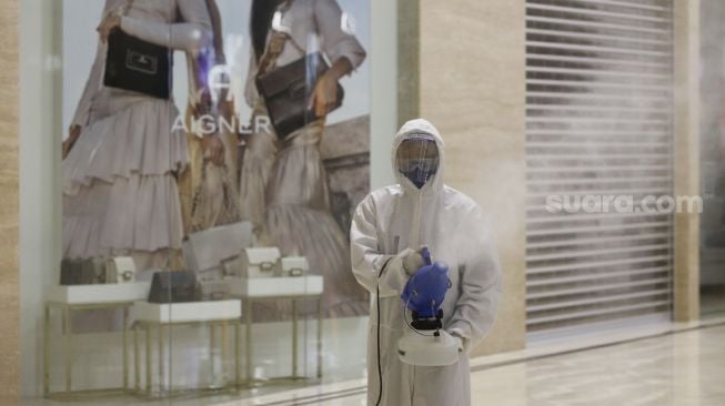 Petugas menyemprotkan cairan disinfektan di Mal Senayan City, Jakarta, Selasa (9/6). [Suara.com/Angga Budhiyanto]