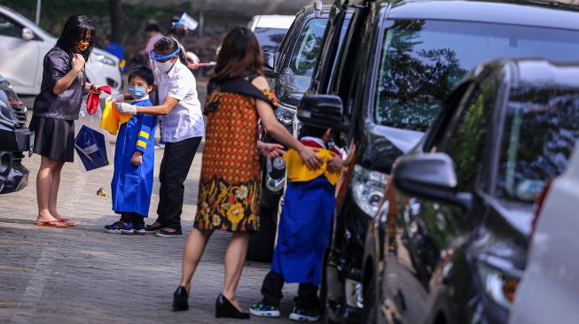 Siswa sekolah Stella Maris bersiap sebelum mengikuti acara kelulusan secara 'drive thru' di Stella Maris School, Kelapa Dua, Kabupaten Tangerang, Banten, Selasa (9/6/2020).  [ANTARA FOTO/Fauzan]
