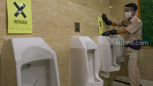 Petugas membersihkan ruang toilet di simulasi pembukaan FX Sudirman, Jakarta Pusat, Selasa (9/6). [Suara.com/Alfian Winanto]