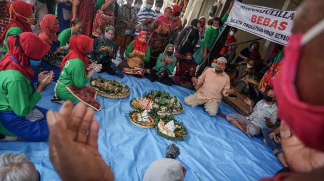 Pedagang dengan membawa nasi tumpeng memanjatkan doa saat Syukuran Pedagang di Pasar Kadipolo, Solo, Jawa Tengah, Rabu (10/6/2020). . [ANTARA FOTO/Mohammad Ayudha]