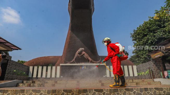 Petugas menyemprotkan disinfektan di Museum Reptil, Taman Mini Indonesia Indah, Jakarta Timur, Rabu (10/6). [Suara.com/Alfian Winanto]