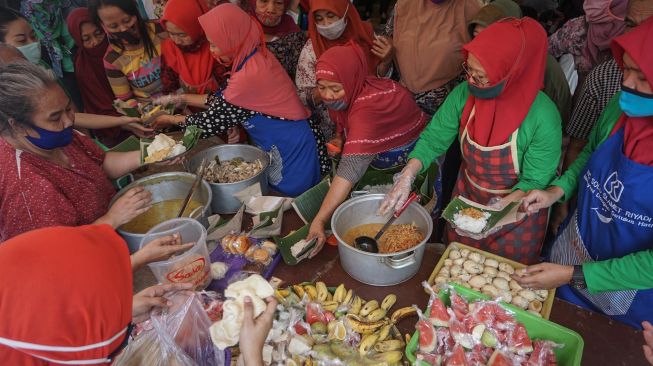 Pedagang membagikan nasi liwet kepada warga saat Syukuran Pedagang di Pasar Kadipolo, Solo, Jawa Tengah, Rabu (10/6/2020). [ANTARA FOTO/Mohammad Ayudha]
