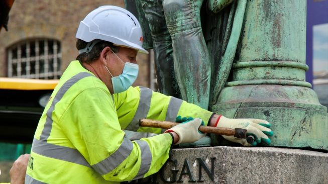 Pekerja pemerintah kota London menurunkan patung pemilik dan pedagang budak Robert Milligan setelah disepakatinya petisi di distrik West India Quay, London, Inggris pada 9 Juni 2020. [Foto/Anadolu Agency]