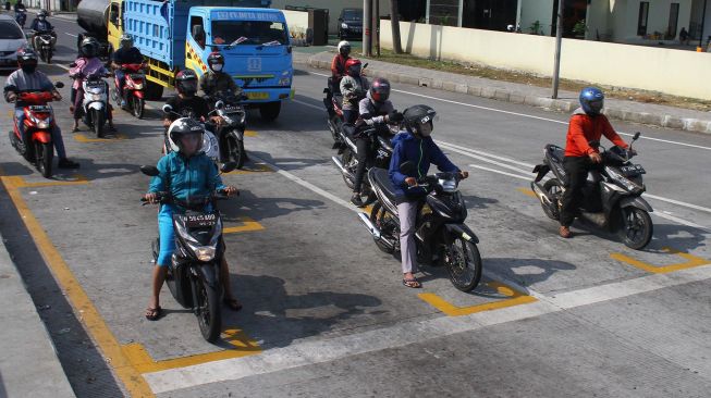 Pengendara motor berhenti di belakang garis untuk menjaga jarak antarpengendara di Karanglo, Malang, Jawa Timur, Kamis (11/6/2020). [ANTARA FOTO/Ari Bowo Sucipto]
