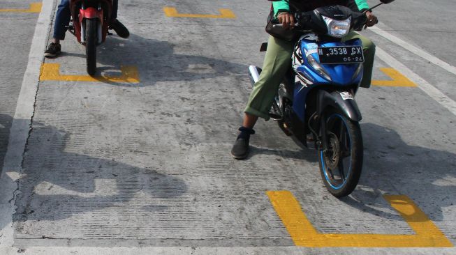 Pengendara motor berhenti di belakang garis untuk menjaga jarak antarpengendara di Karanglo, Malang, Jawa Timur, Kamis (11/6/2020). [ANTARA FOTO/Ari Bowo Sucipto]
