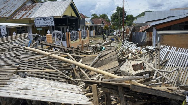 Seorang warga membersihkan perabotan dari lumpur pascabanjir bandang di Ipilo Kota Gorontalo, Gorontalo, Jumat (12/6). [ANTARA FOTO/Adiwinata Solihin]