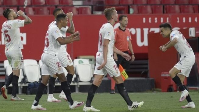 Para pemain Sevilla merayakan gol Fernando (tengah) ke gawang Real Betis dalam lanjutan Liga Spanyol di  Ramon Sanchez Pizjuan stadium. CRISTINA QUICLER / AFP