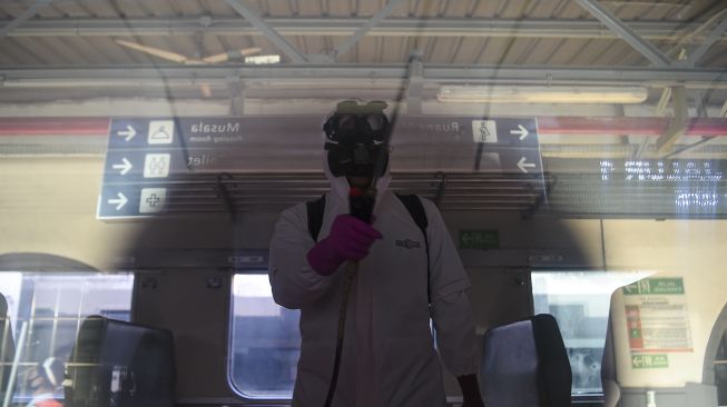 Petugas menyemprotkan disinfektan di dalam gerbong Kereta Api (KA) Serayu di Stasiun Pasar Senen, Jakarta, Jumat (12/6). [ANTARA FOTO/Nova Wahyudi]