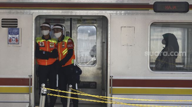 Petugas keamanan berjaga di gerbong Kereta Rel Listrik (KRL) di Stasiun Tanah Abang, Jakarta, Jumat (12/6). [Suara.com/Angga Budhiyanto]