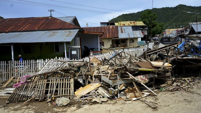 Warga membersihkan rumahnya dari lumpur pascabanjir bandang di Kelurahan Bugis, Kota Gorontalo, Gorontalo, Jumat (12/6). [ANTARA FOTO/Adiwinata Solihin]