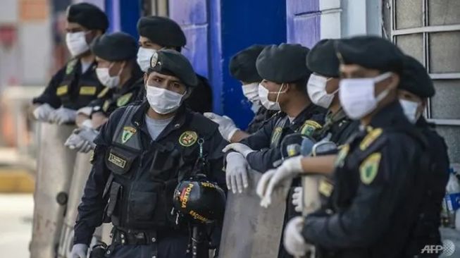 Petugas polisi berjaga di pasar Caqueta di utara Lima, Peru. (AFP/ERNESTO BENAVIDES)