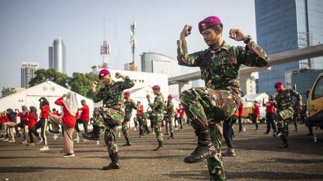 Prajurit Marinir dan relawan Palang Merah Indonesia (PMI) mengikuti senam Zumba bersama Zin Phyo di Gudang Darurat Nasional Penanganan COVID-19 PMI, Jakarta, Sabtu (13/6). [ANTARA FOTO/Aprillio Akbar]