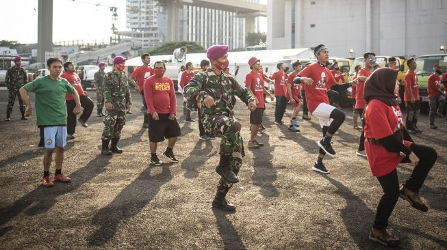 Prajurit Marinir dan relawan Palang Merah Indonesia (PMI) mengikuti senam Zumba bersama Zin Phyo di Gudang Darurat Nasional Penanganan COVID-19 PMI, Jakarta, Sabtu (13/6). [ANTARA FOTO/Aprillio Akbar]