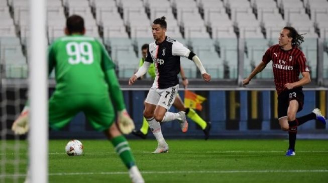 Bintang Juventus Cristiano Ronaldo (tengah) membawa bola ditempel oleh gelandang AC Milan Diego Laxalt di semifinal Coppa Italia di Allianz stadium, Turin. Miguel MEDINA / AFP