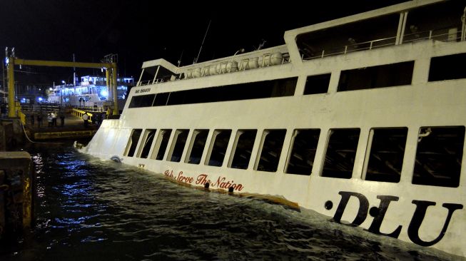 KMP Dharma Rucitra III berada dalam posisi miring dan hampir tenggelam di Dermaga 2 Pelabuhan Padangbai, Karangasem, Bali, Sabtu (13/6) dini hari. [ANTARA FOTO/Fikri Yusuf]