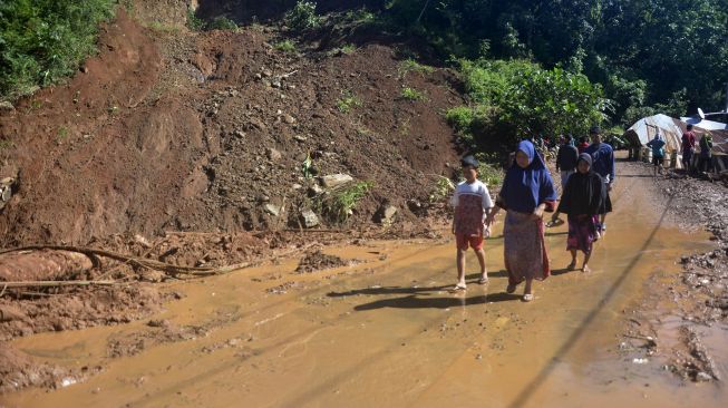 Warga berjalan di sekitar lokasi tanah longsor di Desa Rumbia, Kabupaten Jeneponto, Sulawesi Selatan, Minggu (14/6/2020). [ANTARA FOTO/Abriawan Abhe]
