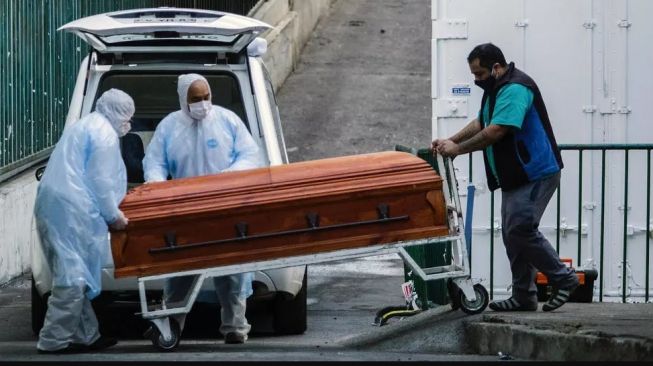 Petugas rumah duka mendorong peti mati seorang korban Covid-19 di Valparaiso, Chili, 12 Juni 2020. (Adriana Thomasa Carballo/AFP)