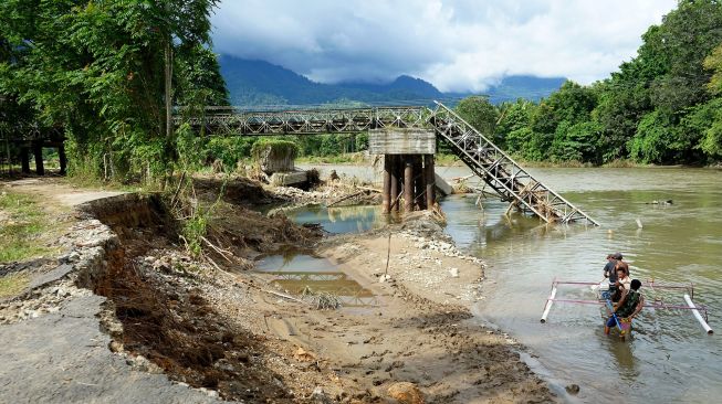 Warga menyewakan jasa penyeberangan dengan menggunakan perahu untuk melintasi sungai Bone dengan tarif Rp5.000 per orang di Alale, Kabupaten Bone Bolango, Gorontalo, Minggu (14/6/2020).  ANTARA FOTO/Adiwinata Solihin
