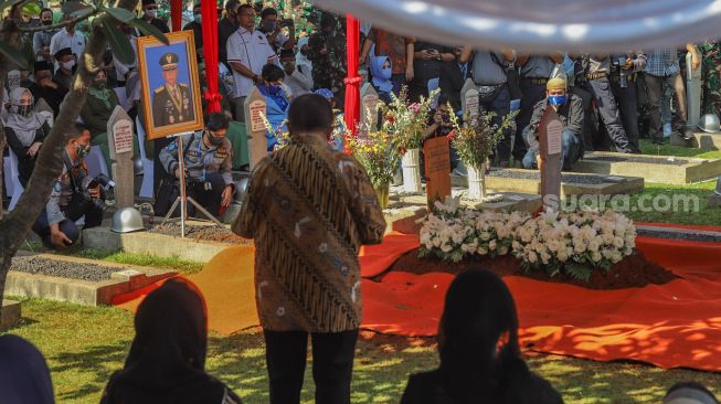 Sambutan keluarga saat upacara pemakaman mantan Kepala Staf TNI Angkatan Darat (KSAD) Letjen TNI Pramono Edhie di Taman Makam Pahlawan (TMP), Kalibata, Jakarta Selatan, Minggu (14/6). [Suara.com/Alfian Winanto]
