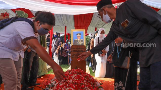 Pelayat menaburkan bunga di makam mantan Kepala Staf TNI Angkatan Darat (KSAD) Letjen TNI Pramono Edhie di Taman Makam Pahlawan (TMP), Kalibata, Jakarta Selatan, Minggu (14/6). [Suara.com/Alfian Winanto]