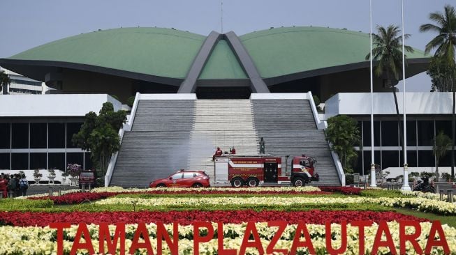 Petugas pemadam kebakaran menyemprotkan cairan disinfektan di Kompleks Parlemen, Senayan, Jakarta, Minggu (14/6/2020). [ANTARA FOTO/Puspa Perwitasari]