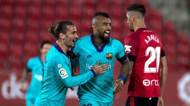 Gelandang Bacelona, Arturo Vidal (tengah) merayakan gol ke gawang Mallorca dalam laga lanjutan Liga Spanyol yang digelar di Son Moix Stadium, Minggu (14/6/2020) dini hari WIB. (Foto: AFP/Jaime Reina)