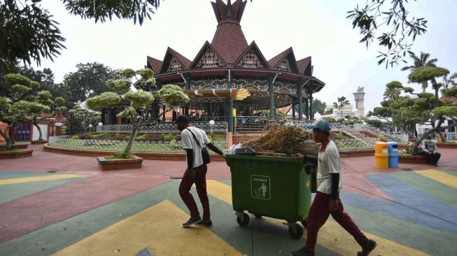 Petugas kebersihan melintas di dekat wahana Turangga Rangga jelang pembukaan kembali Taman Impian Jaya Ancol di Jakarta, Senin (15/6/2020).  [ANTARA FOTO/Puspa Perwitasari]
