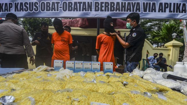 Polisi menunjukkan tersangka beserta barang bukti saat rilis ungkap kasus peredaran atau penyalahgunaan obat-obatan terlarang di Makopolres Kota Banjar, Jawa Barat, Selasa (16/6/2020).  [ANTARA FOTO/Adeng Bustomi]