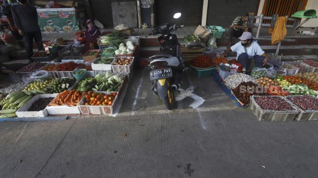 Pedagang menata dagangannya di Pasar Perumnas Klender, Jakarta, Selasa (16/6). [Suara.com/Angga Budhiyanto]