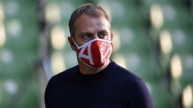 Pelatih Bayern Munich Hansi Flick memakai masker saat skuatnya menghadapi Werder Bremen di Liga Jerman. Martin MEISSNER / POOL / AFP