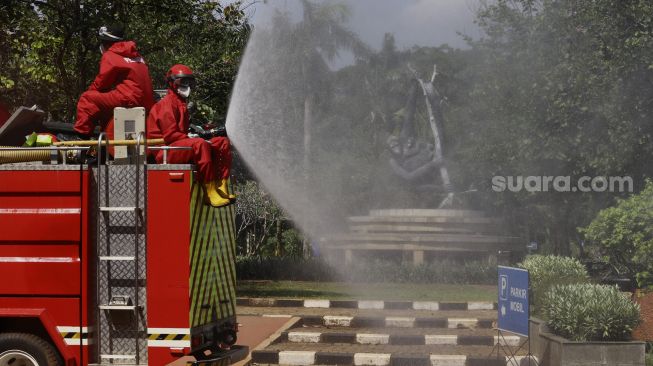 Petugas Pemadam Kebakaran (Damkar) menyemprotkan cairan disinfektan di lingkungan Taman Margasatwa Ragunan (TMR), Jakarta, Rabu (17/6). [Suara.com/Angga Budhiyanto]