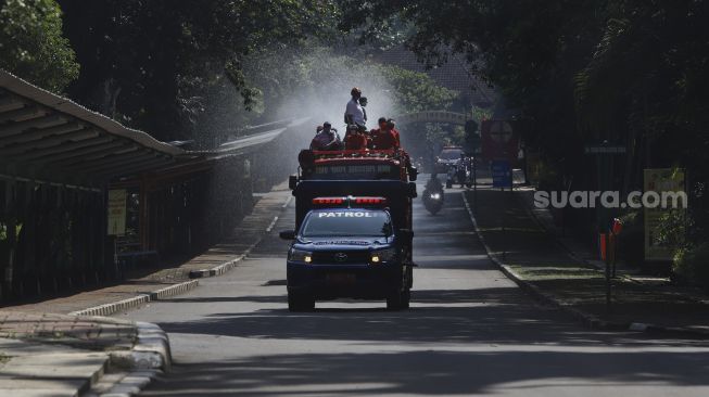 Petugas Pemadam Kebakaran (Damkar) menyemprotkan cairan disinfektan di lingkungan Taman Margasatwa Ragunan (TMR), Jakarta, Rabu (17/6). [Suara.com/Angga Budhiyanto]