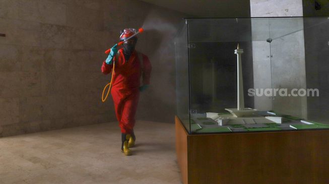 Petugas Pemadam Kebakaran menyemprotkan cairan disinfektan di Kawasan Monumen Nasional (Monas), Jakarta Pusat, Rabu (17/6).  [Suara.com/Alfian Winanto]