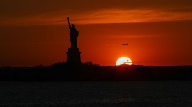 Pemandangan matahari terbenam dan Patung Liberty dari sisi Brooklyn di New York, Amerika Serikat pada 16 Juni 2020.  [Foto/Anadolu Agency]