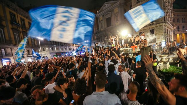 Suporter Napoli merayakan kemenangan atas Juventus pada final Coppa Italia di pusat Kota Napoli, Italia,Kamis (18/6) dini hari WIB.  [Carlo Herman/AFP]