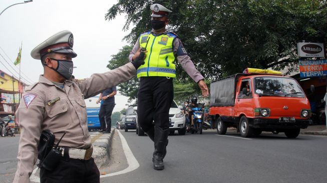 Ahmad Junaedi (kiri) sukarelawan pengatur lalulintas (Superlas) penyandang disabilitas mengatur lalu lintas di Jalan Ciledug Raya, Tangerang, Banten, Kamis (18/6/2020). [ANTARA FOTO/Muhammad Iqbal]