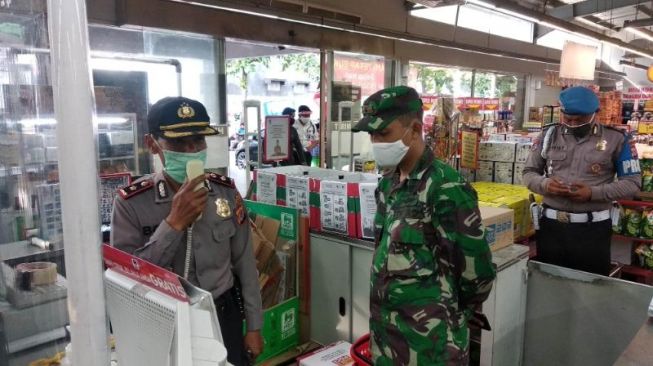 Kapolsek Gondokusuman Kompol Bonifasius Slamet (kiri) dan Danramil Gondokusuman Mayor Inf Acuk Andrianto (kanan) memberi sosialisasi terhadap pencegahan Covid-19 di Supermarket Superindo, Gondokusuman, Kota Yogyakarta, Kamis (18/6/2020). - (SuaraJogja.id/Muhammad Ilham Baktora)