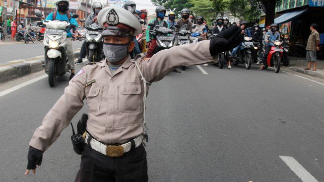 Ahmad Junaedi (kiri) sukarelawan pengatur lalulintas (Superlas) penyandang disabilitas mengatur lalu lintas di Jalan Ciledug Raya, Tangerang, Banten, Kamis (18/6/2020).  [ANTARA FOTO/Muhammad Iqbal]