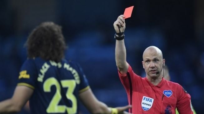 Wasit Anthony Taylor (kanan) memberikan kartu merah kepada bek Arsenal David Luiz saat skuatnya menghadapi Manchester City di Etihad Stadium, Manchester. PETER POWELL / POOL / AFP