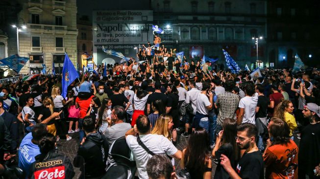 Suporter Napoli merayakan kemenangan atas Juventus pada final Coppa Italia di pusat Kota Napoli, Italia,Kamis (18/6) dini hari WIB.  [Carlo Herman/AFP]