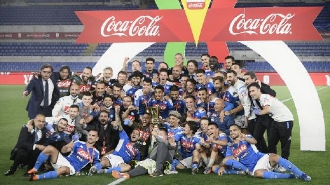 Para pemain Napoli dan juga staff pelatih merayakan sukses mereka meraih trofi Coppa Italia setelah mengalahkan Juventus pada laga final di Olympic stadium, Roma. Filippo MONTEFORTE / AFP