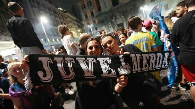 Suporter Napoli merayakan kemenangan atas Juventus pada final Coppa Italia di pusat Kota Napoli, Italia,Kamis (18/6) dini hari WIB.  [Carlo Herman/AFP]