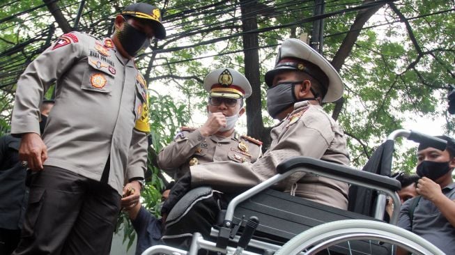 Kapolda Metro Jaya Irjen Pol Nana Sudjana (kiri) berbincang dengan Ahmad Junaedi (kanan) seorang sukarelawan pengatur lalu lintas (Superlas) penyandang disabilitas saat pemberiaan penghargaan di Jalan Ciledug Raya, Tangerang, Banten, Kamis (18/6/2020). [ANTARA FOTO/Muhammad Iqbal]